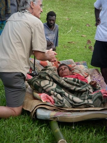 Dr. Bruce tends to patient in improvised stretcher, 2010
